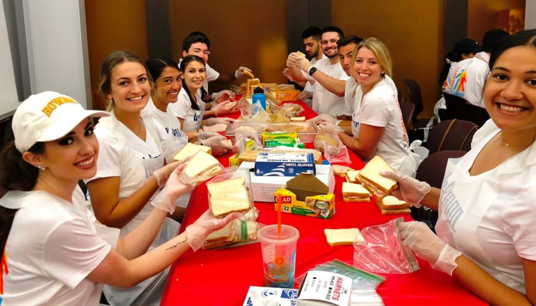 a group of people in white shirts at a table with food