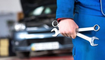 A auto technician holding wrenches