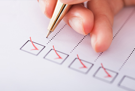 A pen checking off boxes of a list