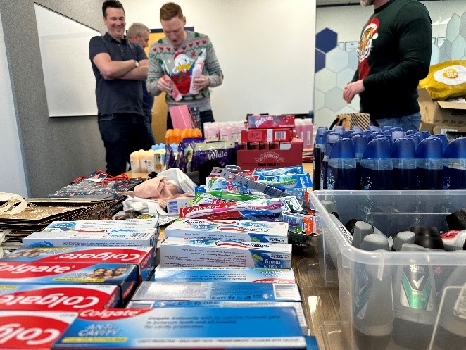 a group of men standing around a table with items on it