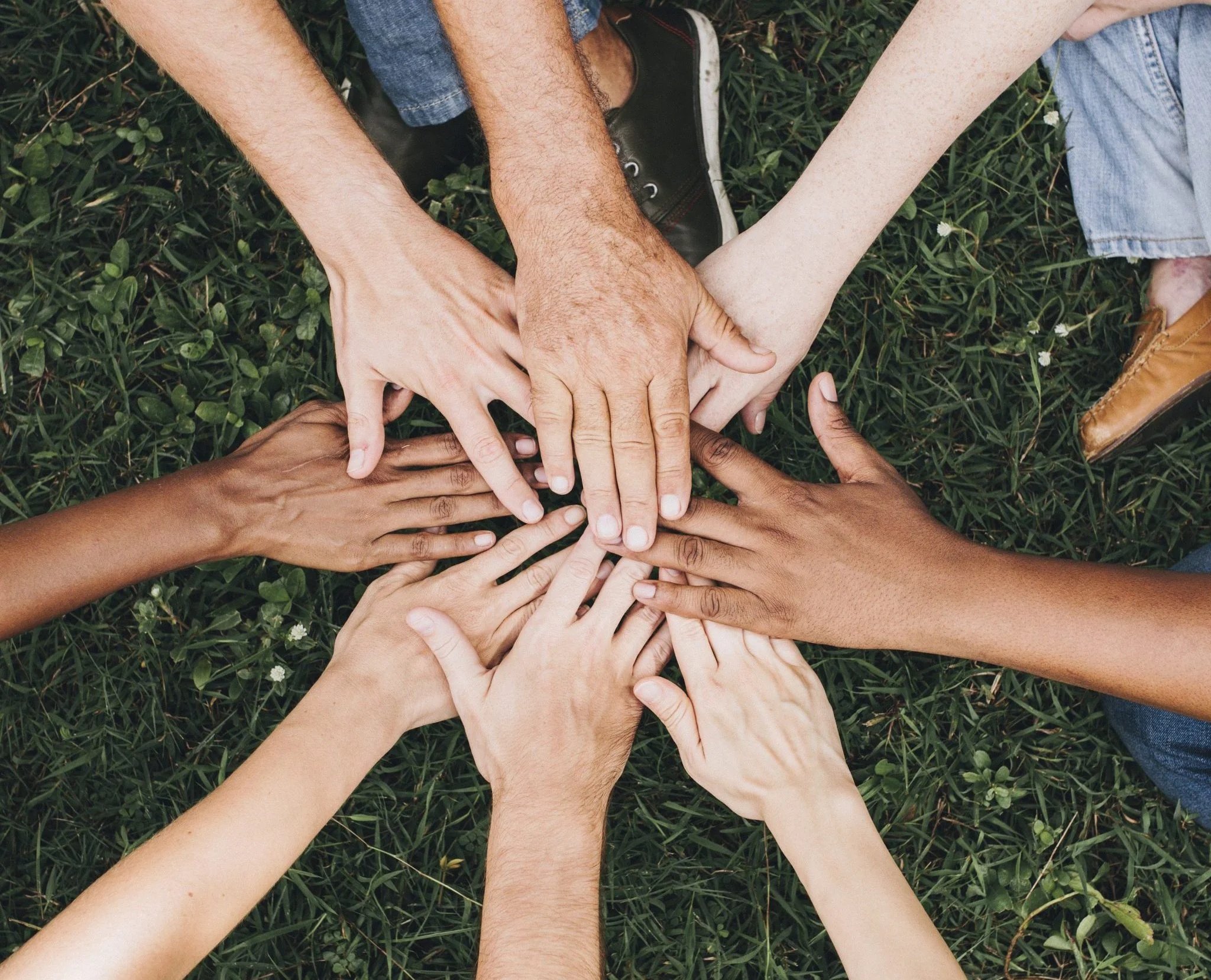 a group of people putting their hands together 