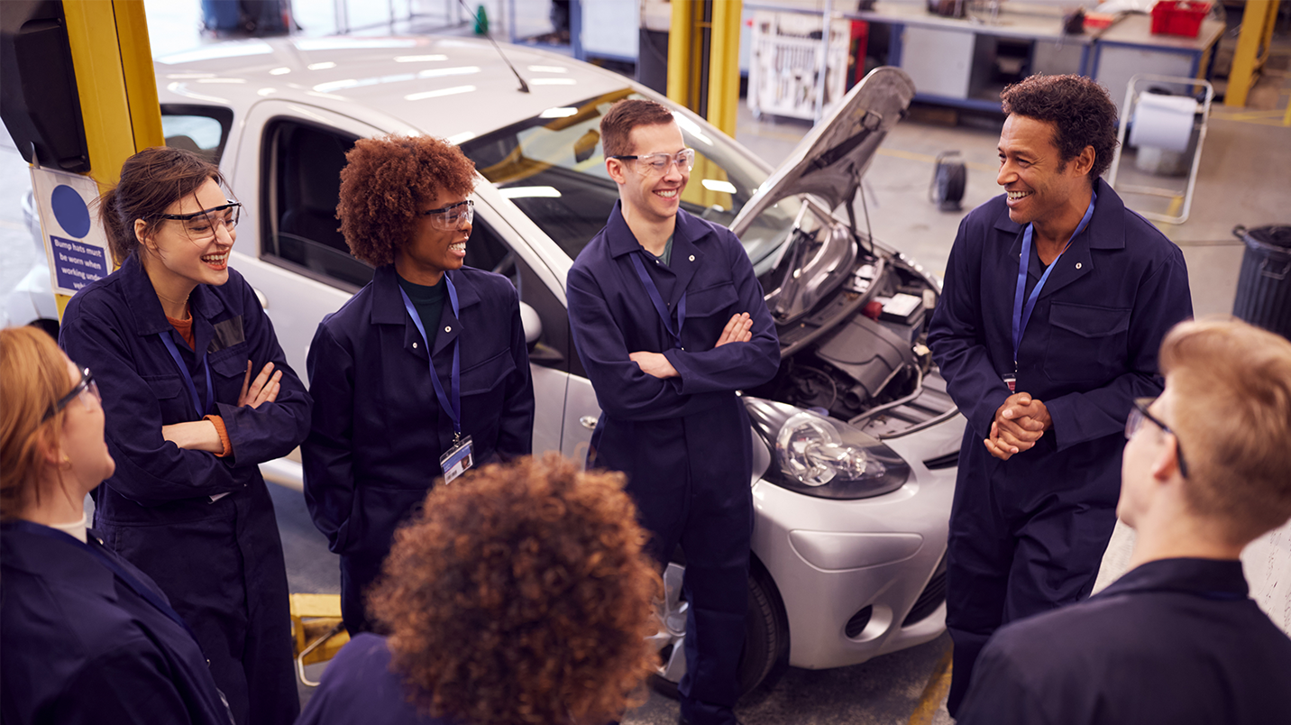 a group of people standing in a room with a car