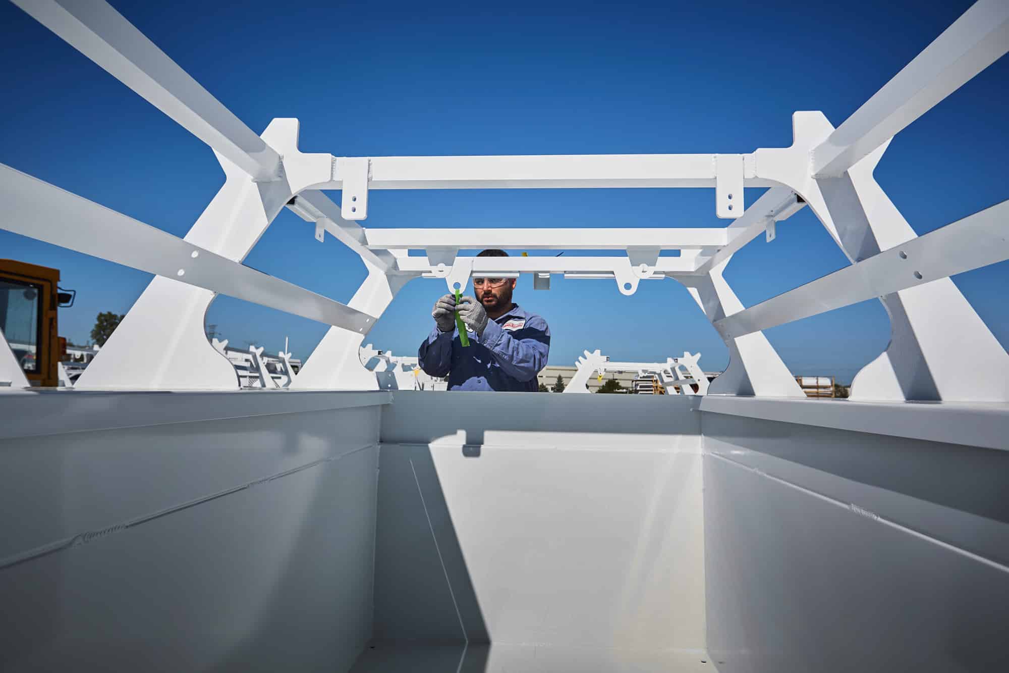 Man adjusting a tape on top of the truck