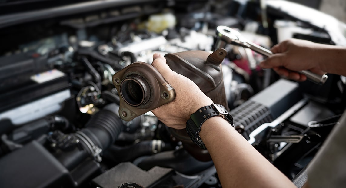 a person holding a car exhaust pipe