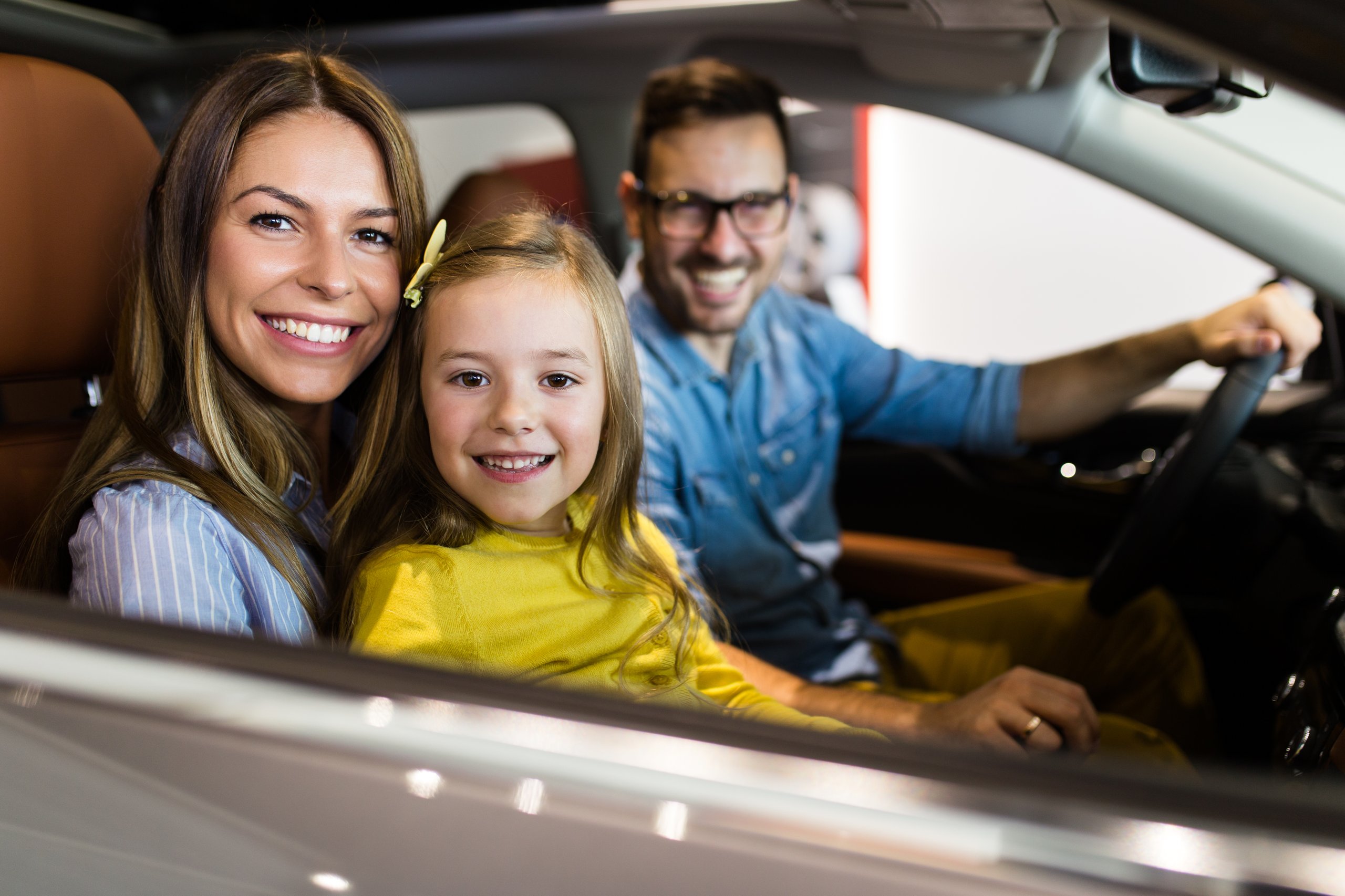 a family sitting in a car smiling