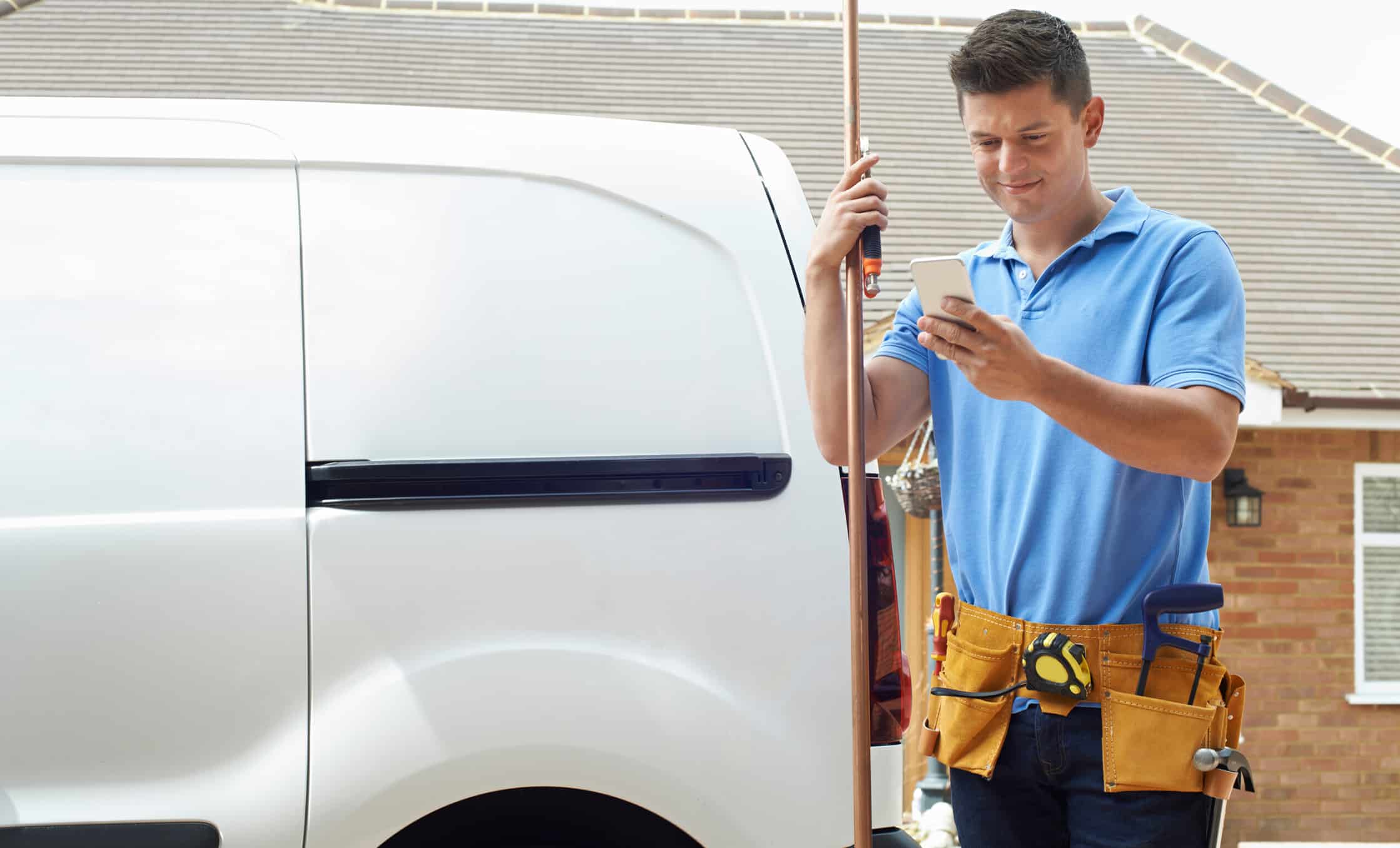 a man holding a phone next to a white van