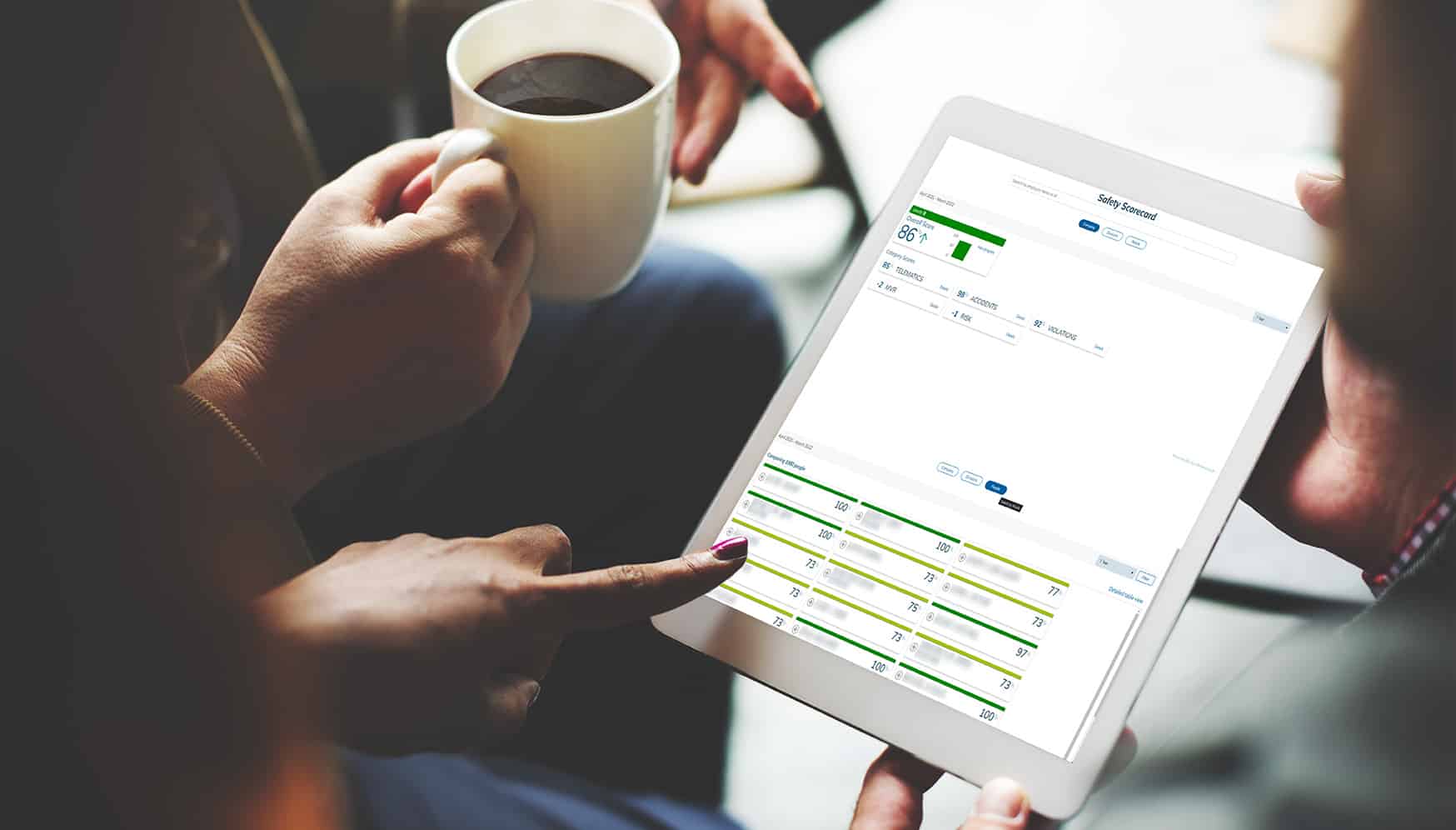 a person holding a cup of coffee and a tablet