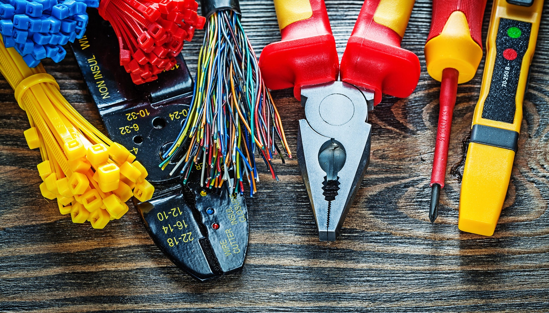 a pair of pliers and wires on a wood surface