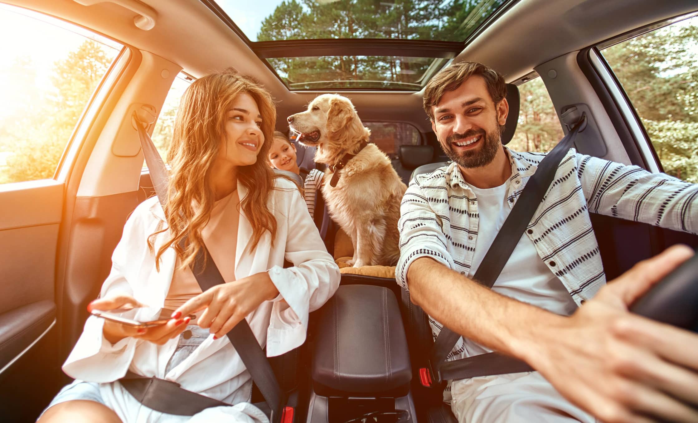 a group of people in a car with a dog and a child