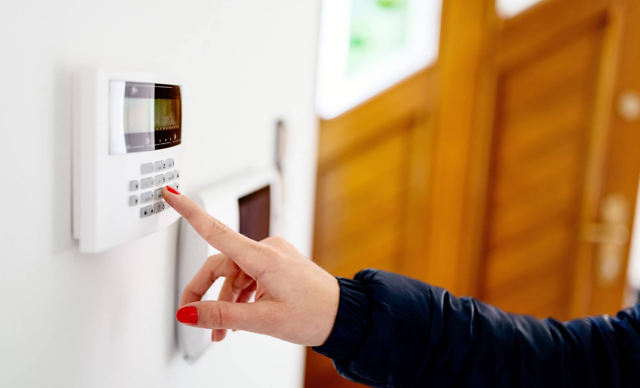 a finger pressing a keypad on a white wall
