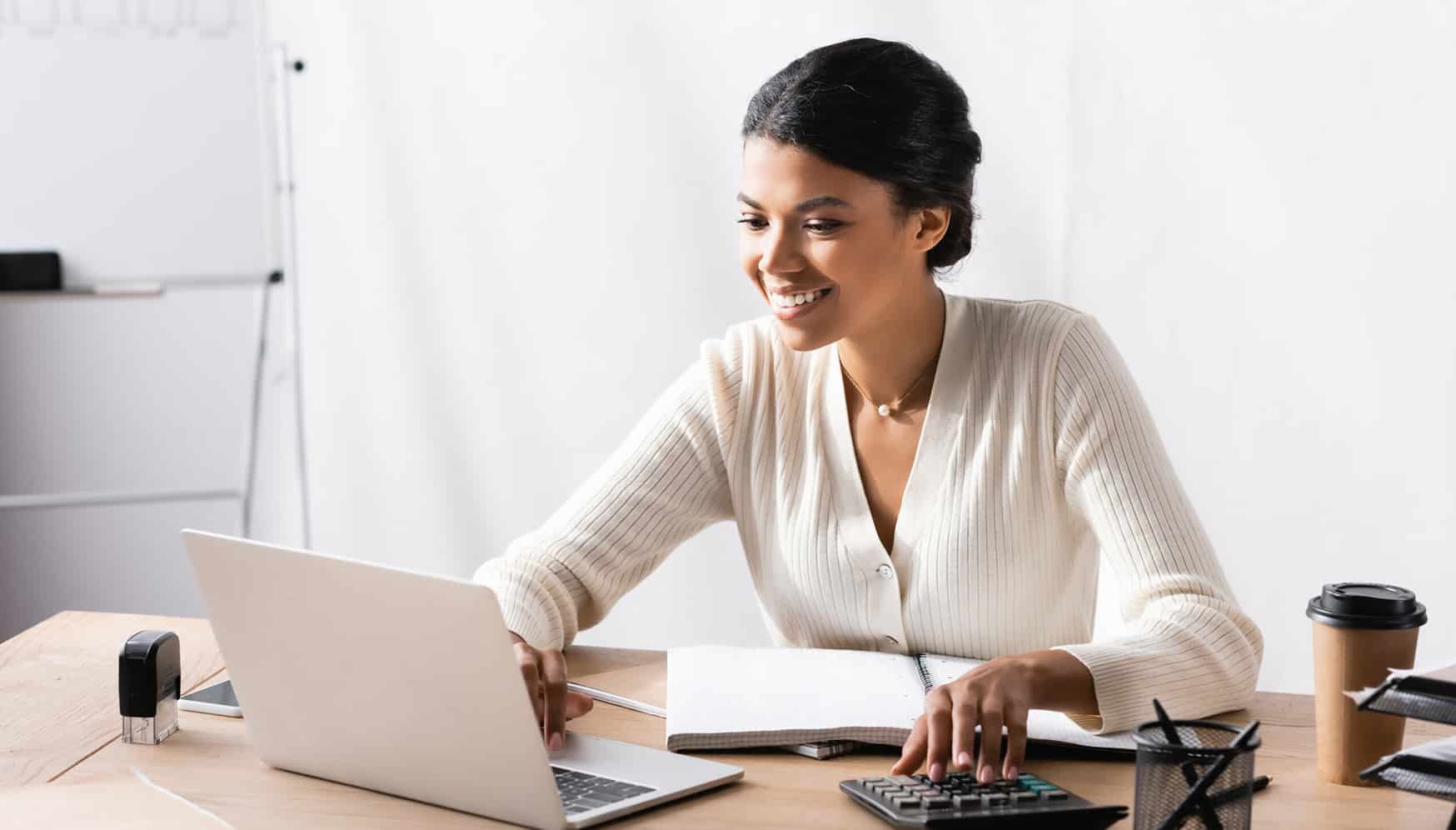 a woman sitting at a desk using a laptop