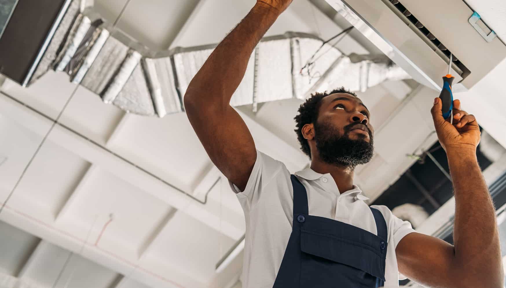 a man in overalls holding up a light