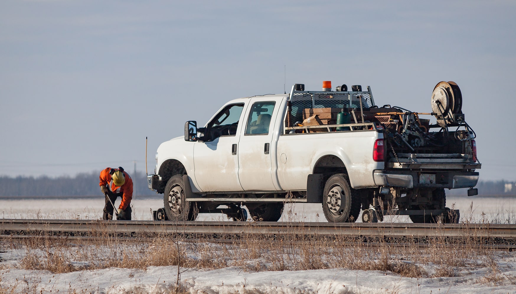 a white truck with a white pick up truck on the tracks