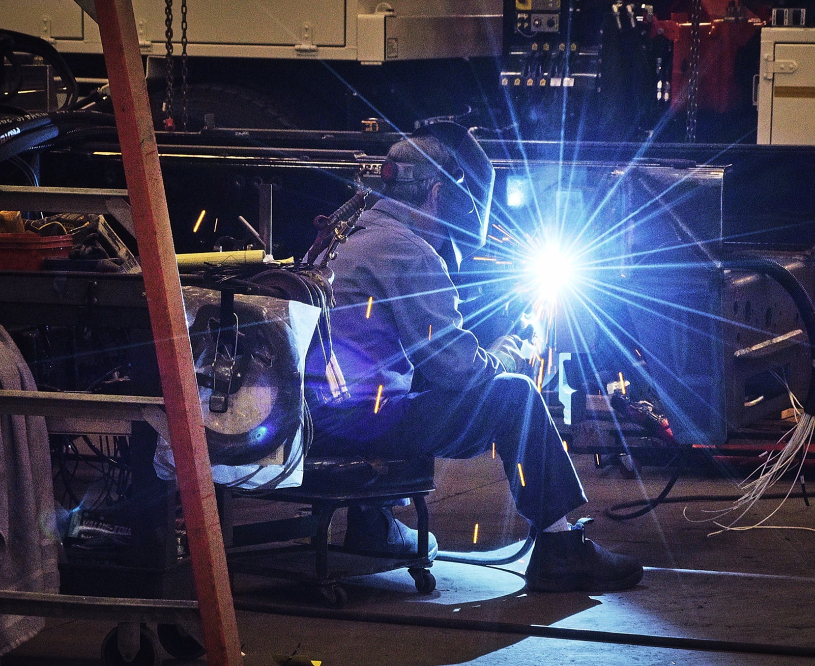 a man wearing a welding mask and holding a welding machine