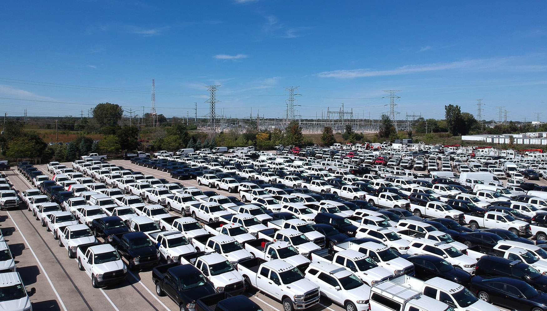 a large lot of white pickup trucks
