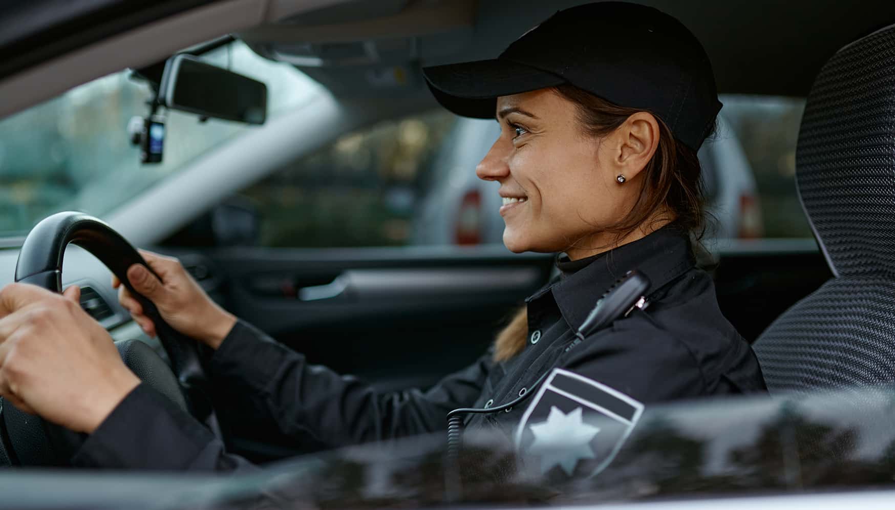a woman in a police uniform driving a car