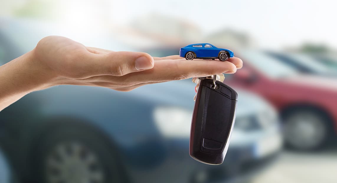 a hand holding a toy car