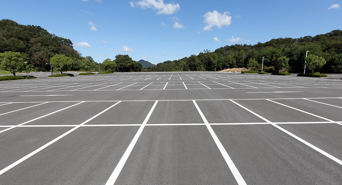 a parking lot with trees in the background