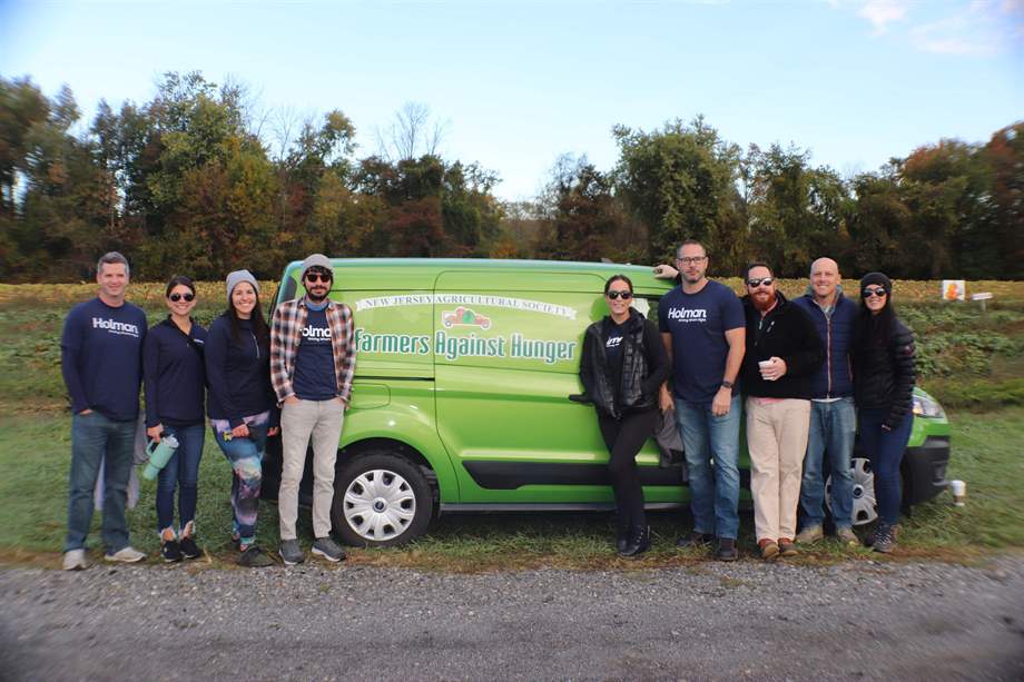 a group of people standing in front of a green van
