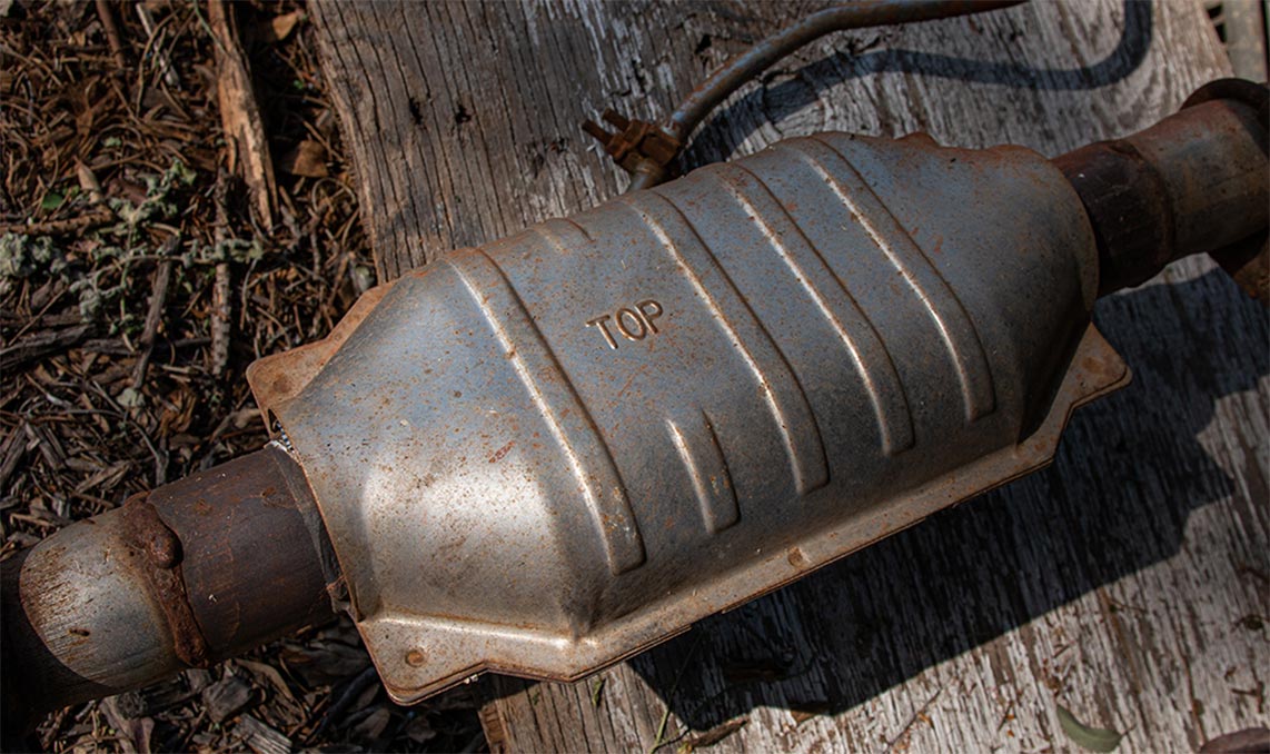 a metal muffler on a wood surface