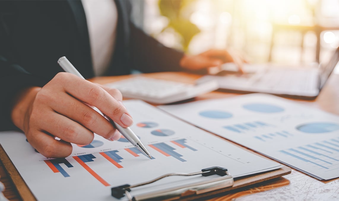 a person holding a pen over a graph