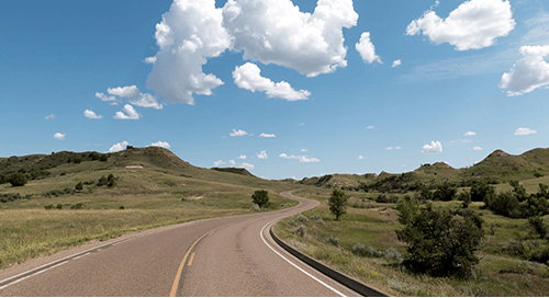 a road going through a grassy landscape