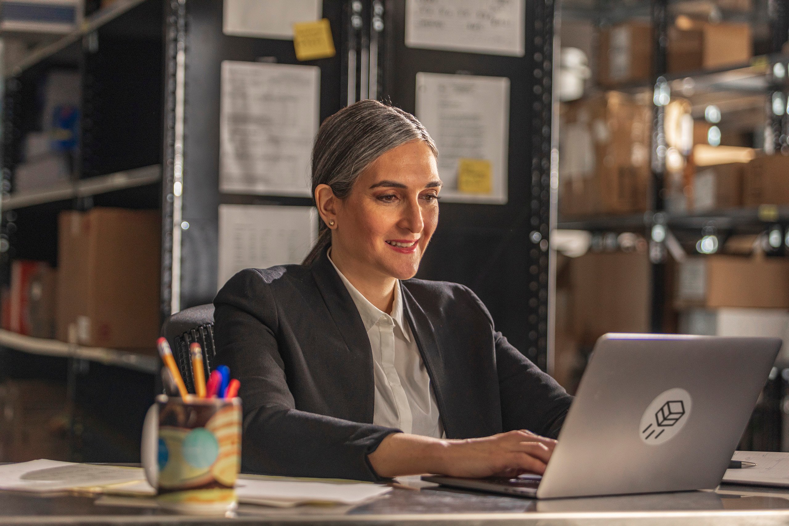 a woman sitting at a desk using a laptop