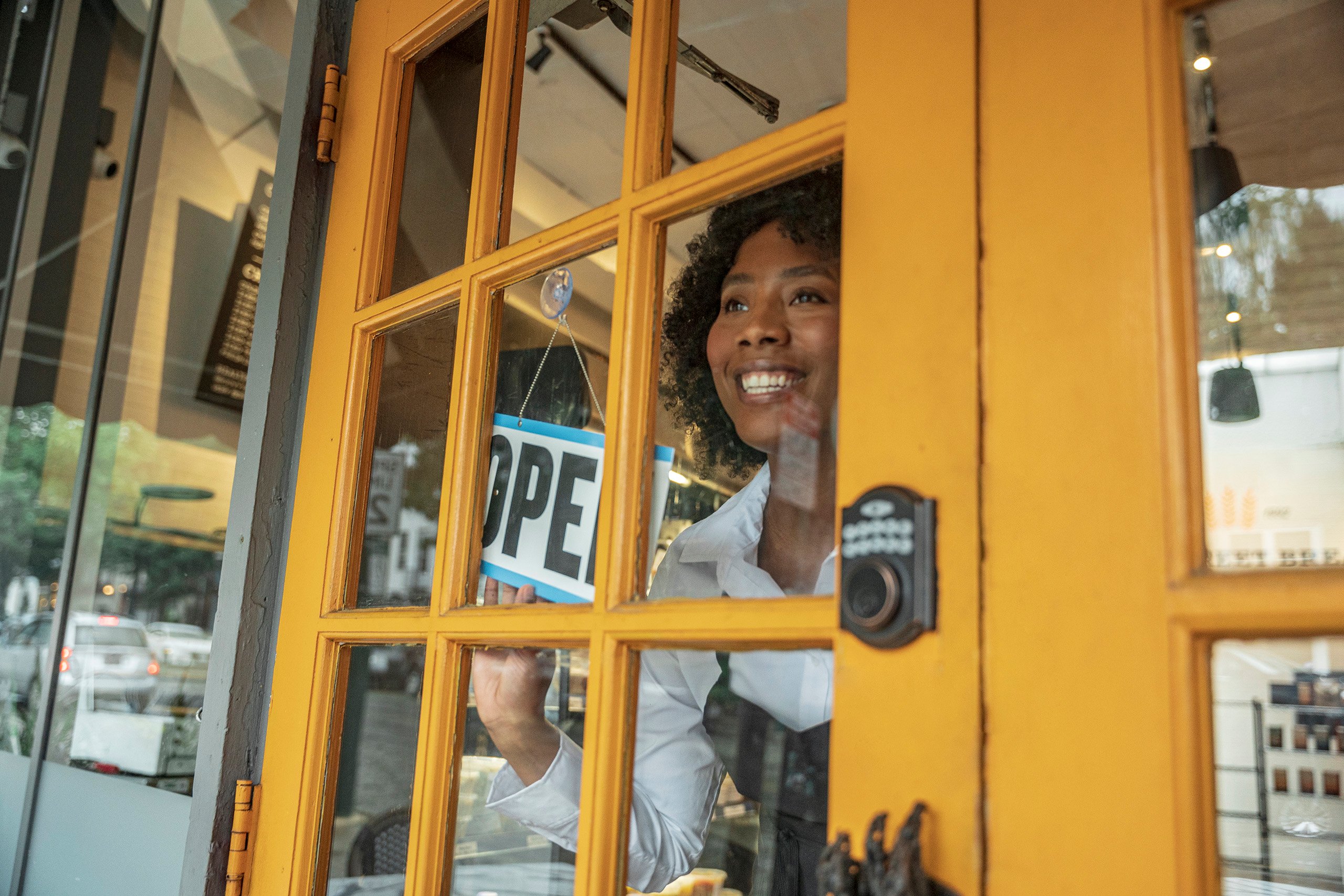 a woman holding a sign in front of a door