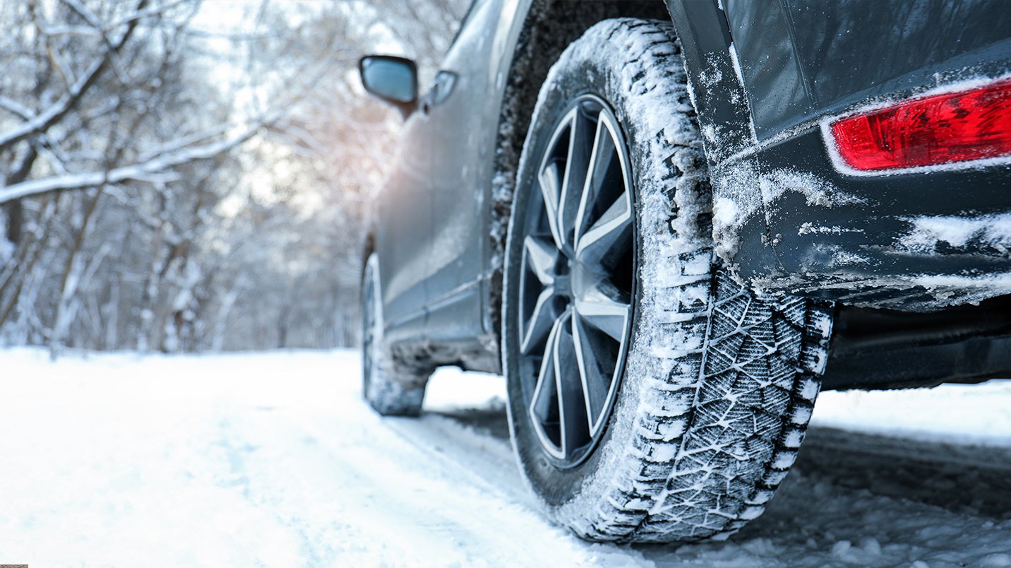 a car with a tire on a snowy road