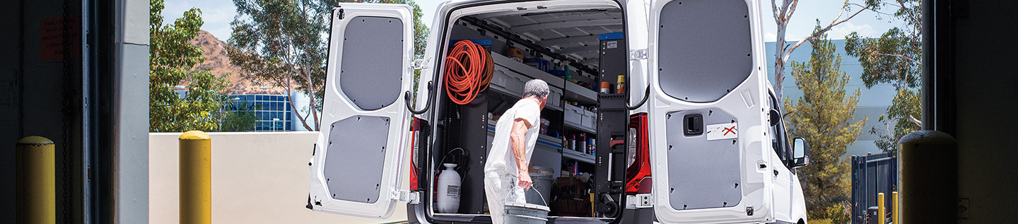 a man carrying a bucket in the back of a van