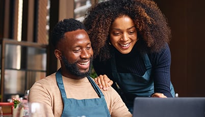 a man and woman looking at a laptop