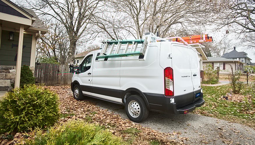 A white light-duty van with ladders on the sides