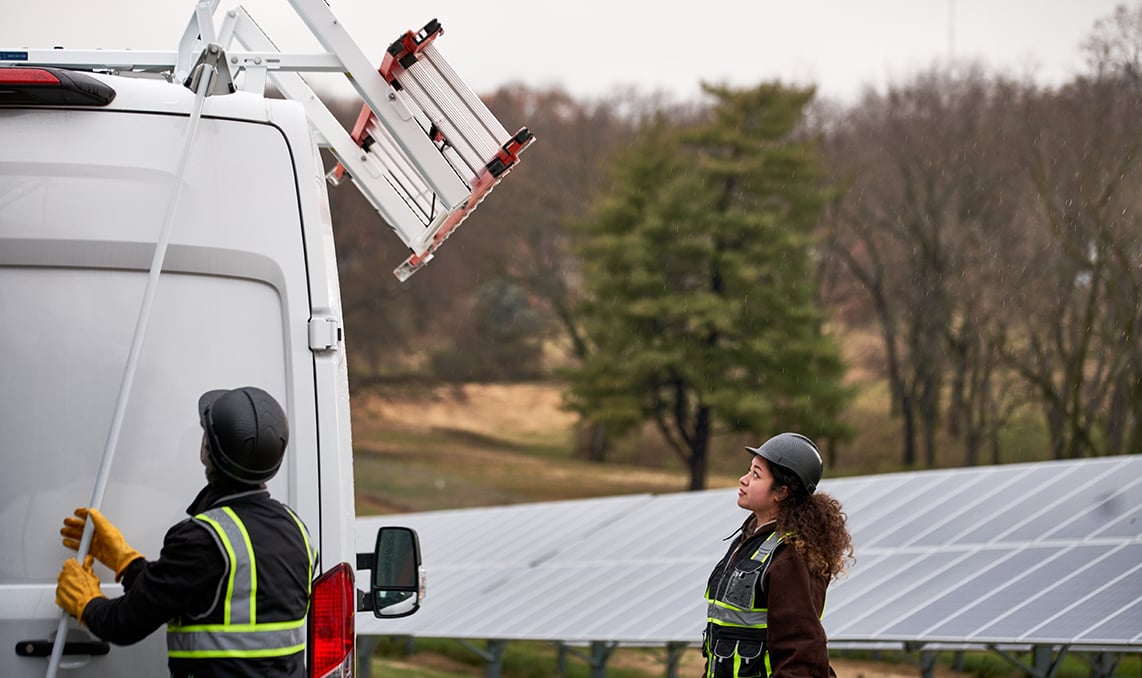 energy workers getting a ladder off of a van