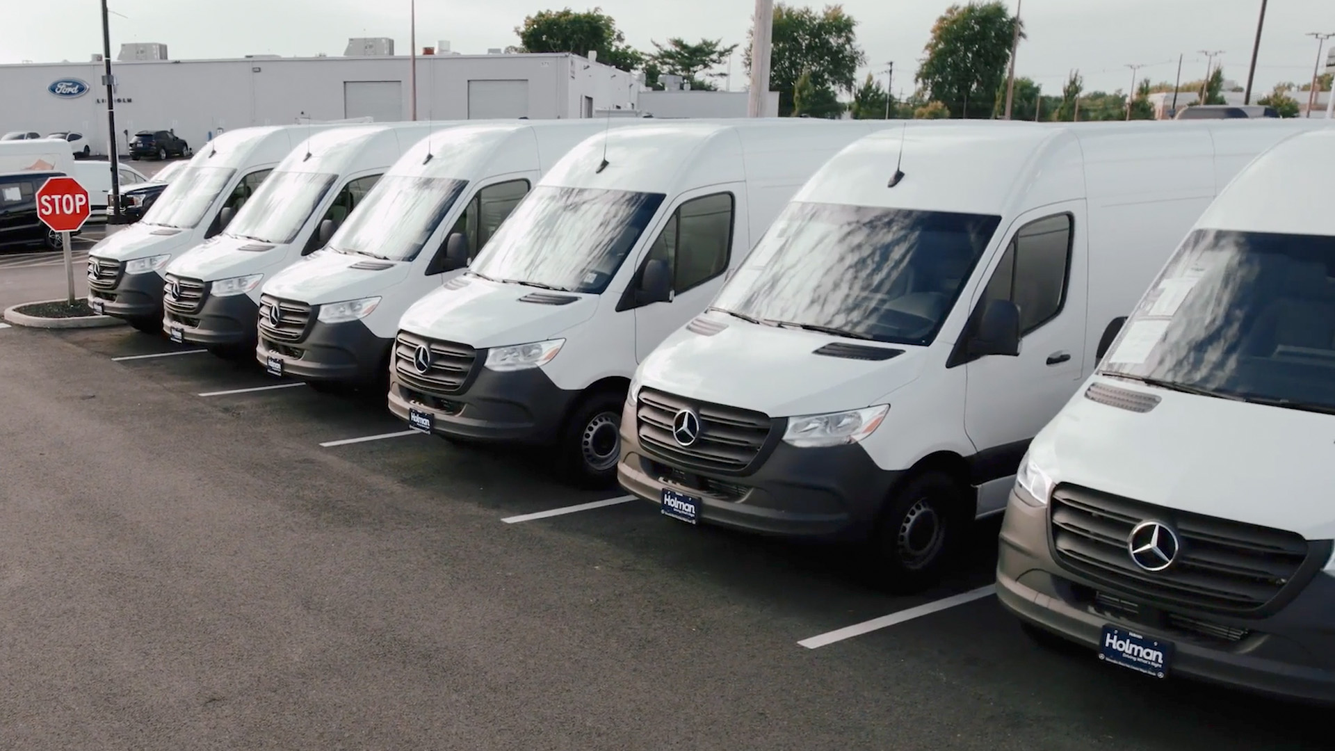 a row of white vans in a parking lot