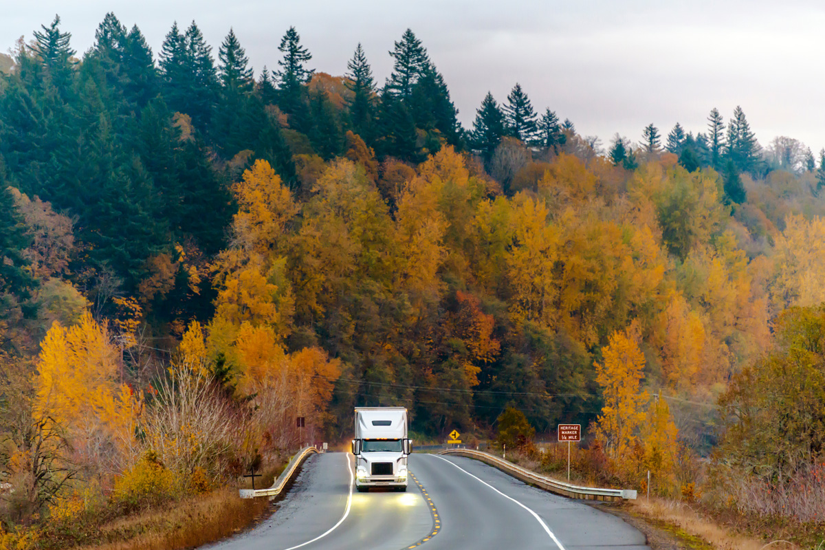 a tractor trailer driving on a road