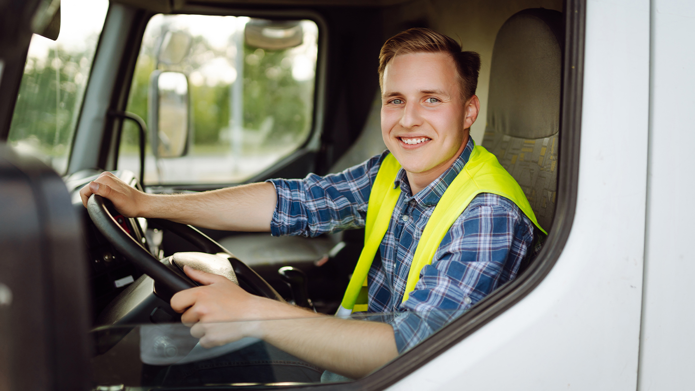 a man in a yellow vest driving a truck