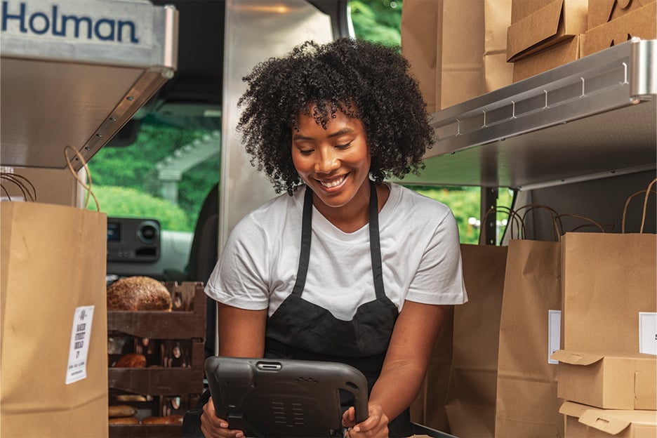 a woman in an apron looking at a tablet
