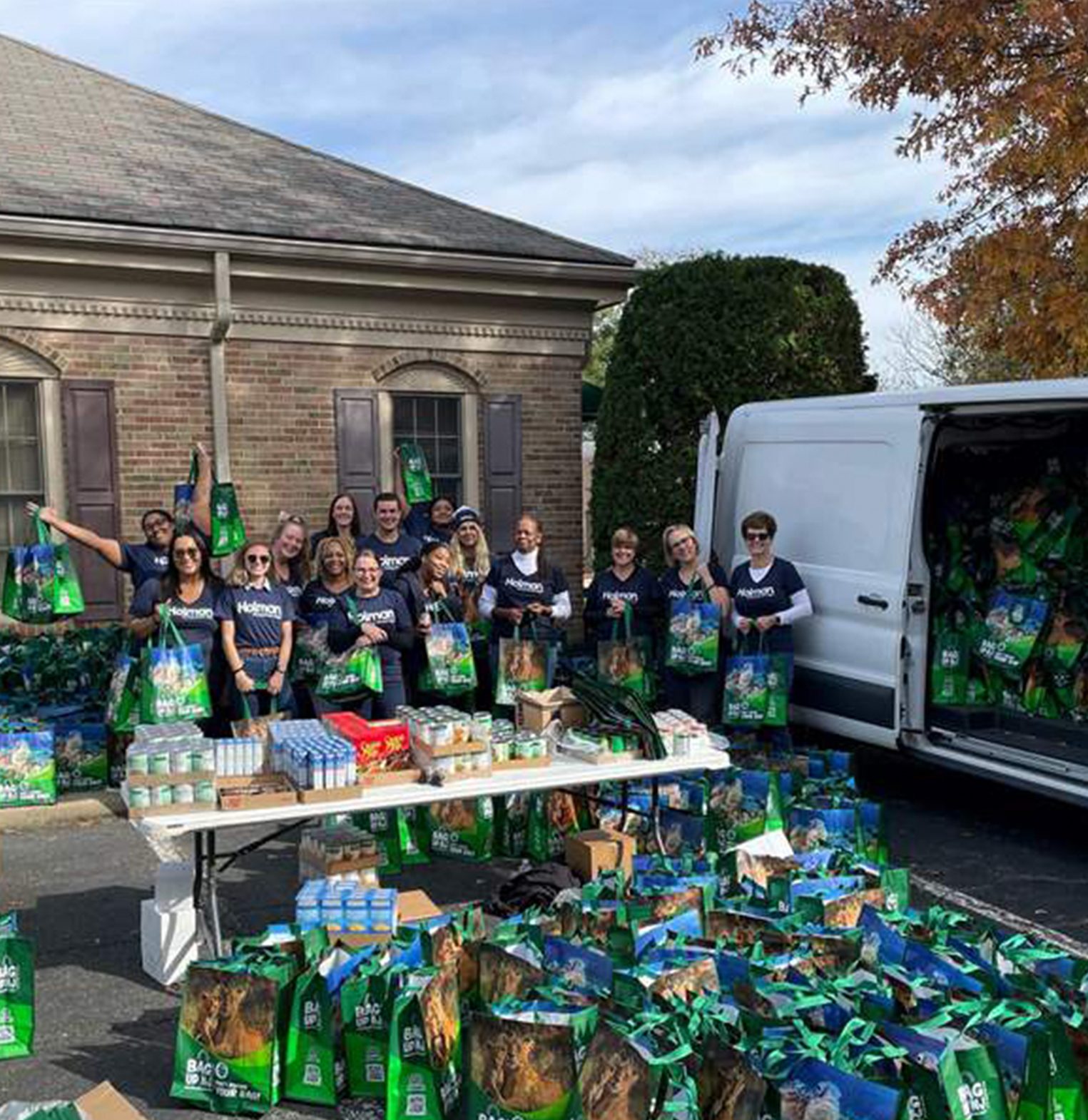 a group of people standing next to a table with food