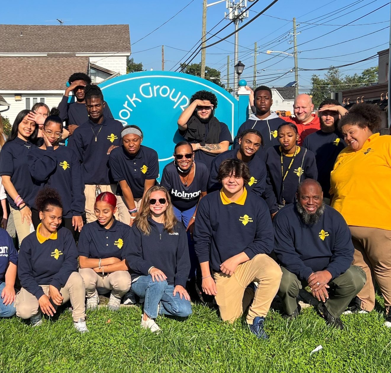 a group of people posing for a photo in front of a sign