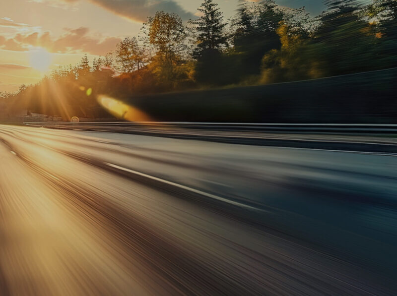 a blurry road with trees in the background
