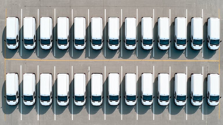 Rows of parked white vehicles.