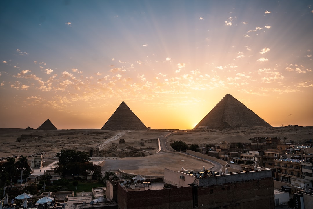 Kamelskarawane vor den Gizeh-Pyramiden bei Sonnenaufgang
