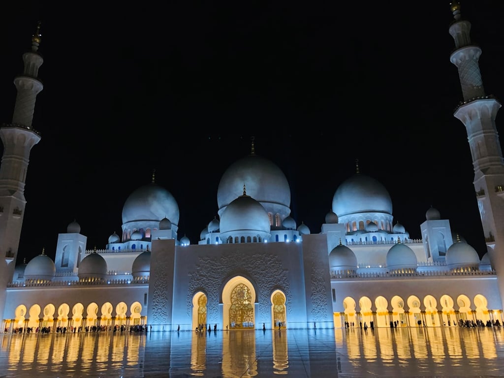 Interior view of Sheikh Zayed Grand Mosque with ornate pillars and chandeliers