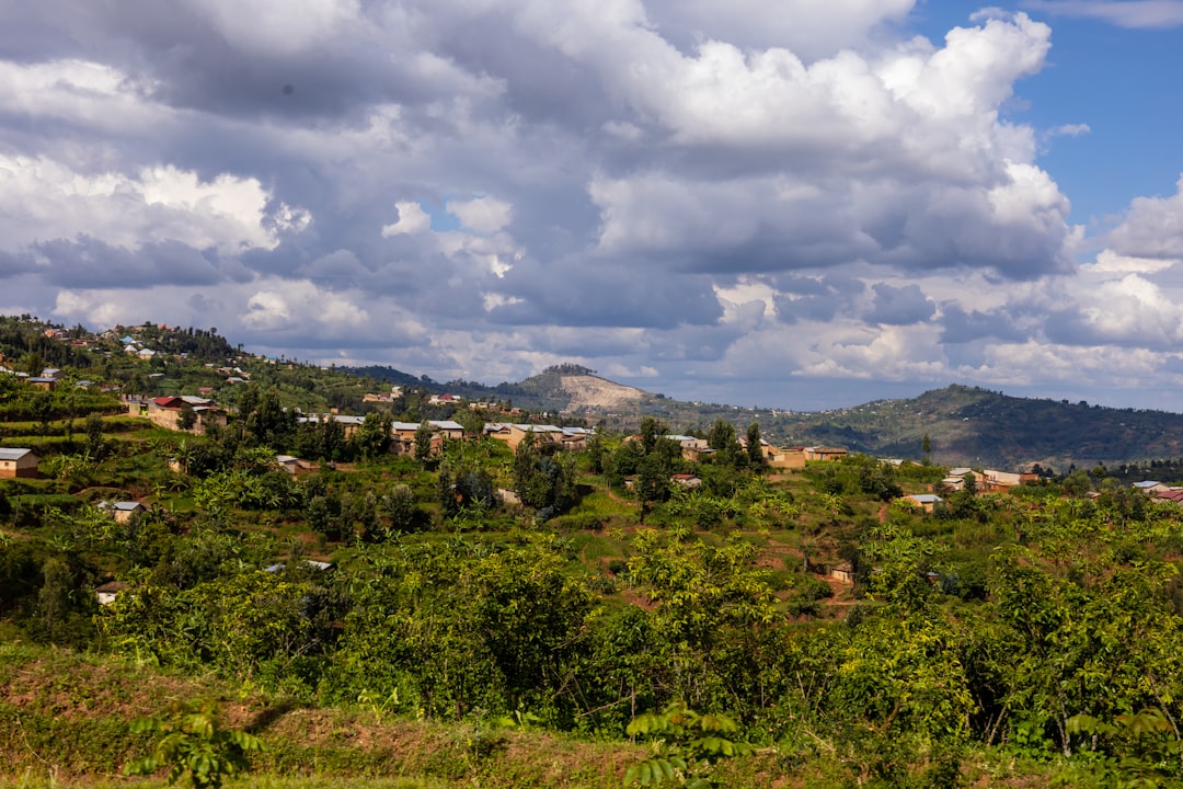 A vibrant Rwandan village with rolling green hills in the background