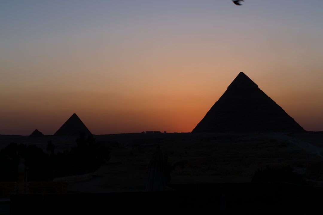 Die Große Sphinx von Gizeh mit einer Pyramide im Hintergrund bei Sonnenuntergang
