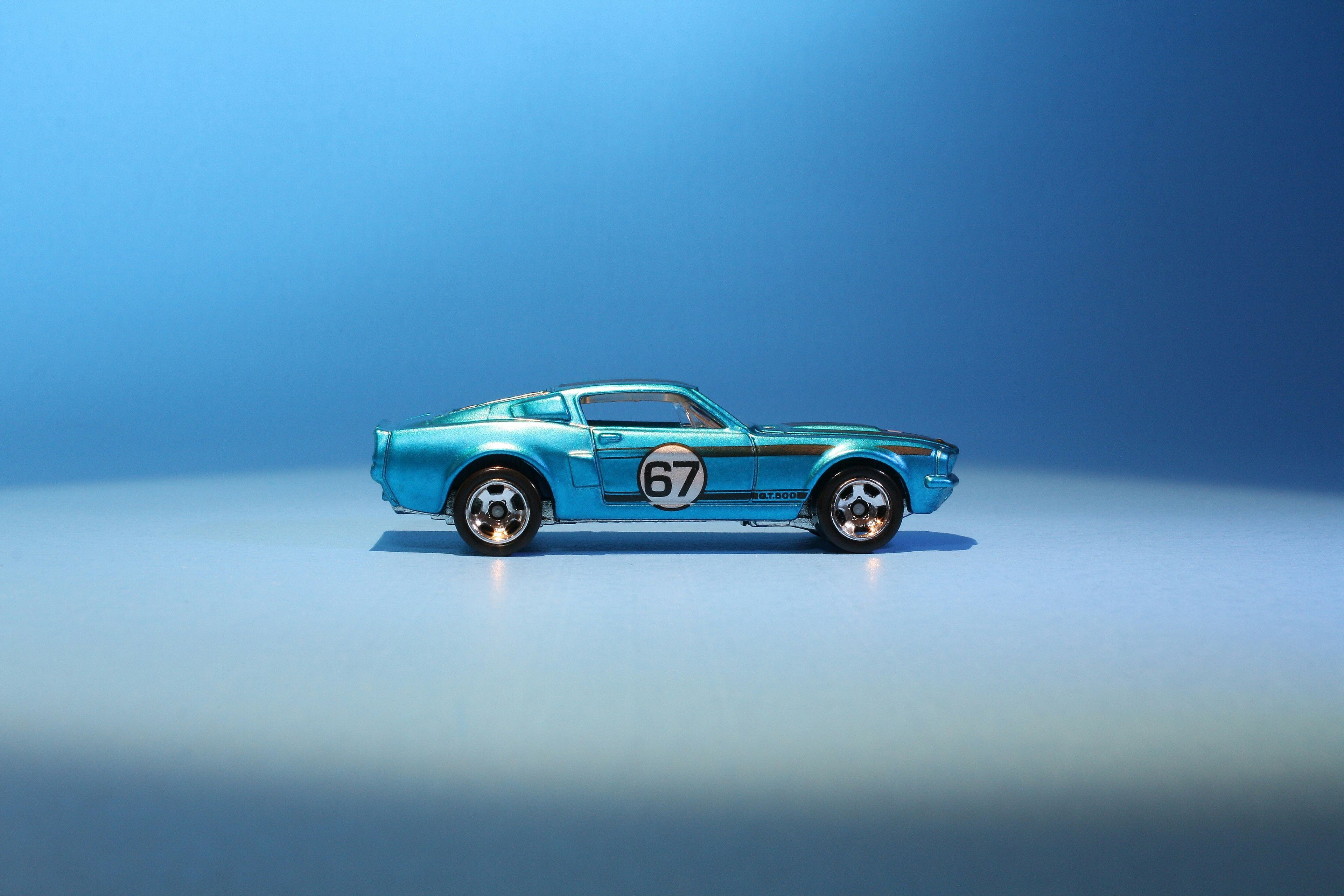 Blue die-cast toy Ford Mustang GT500 on a blue background