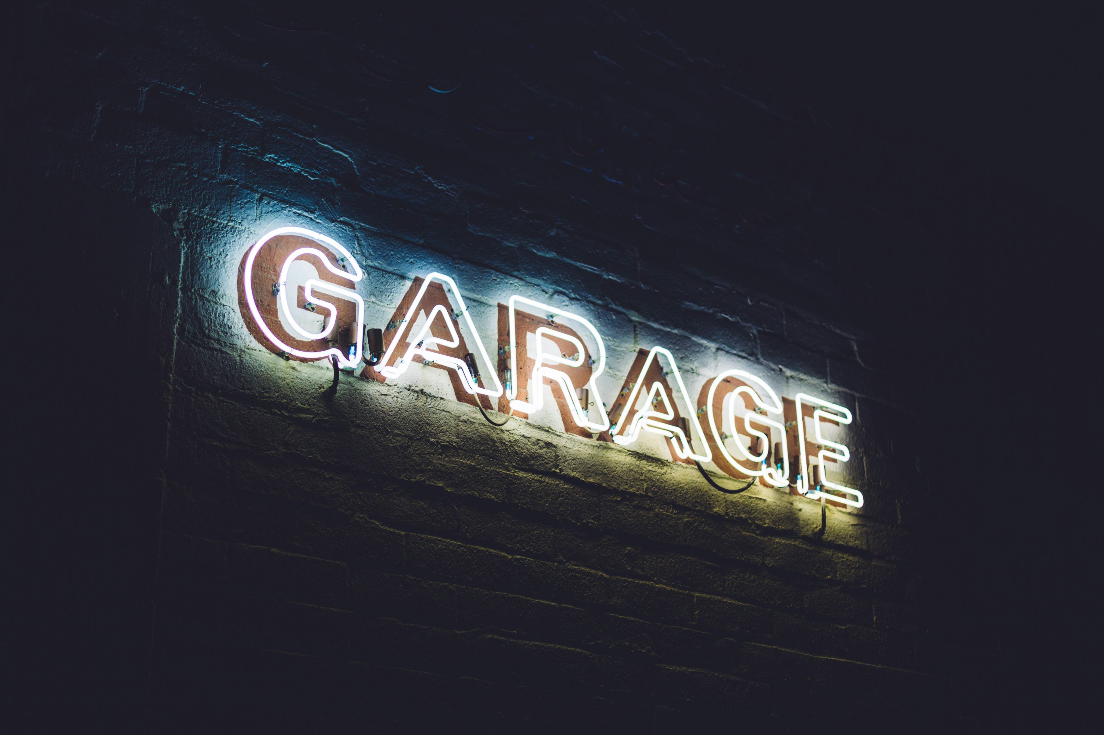 Independent Qatar garage exterior with signage, viewed by a customer on a mobile phone in Doha