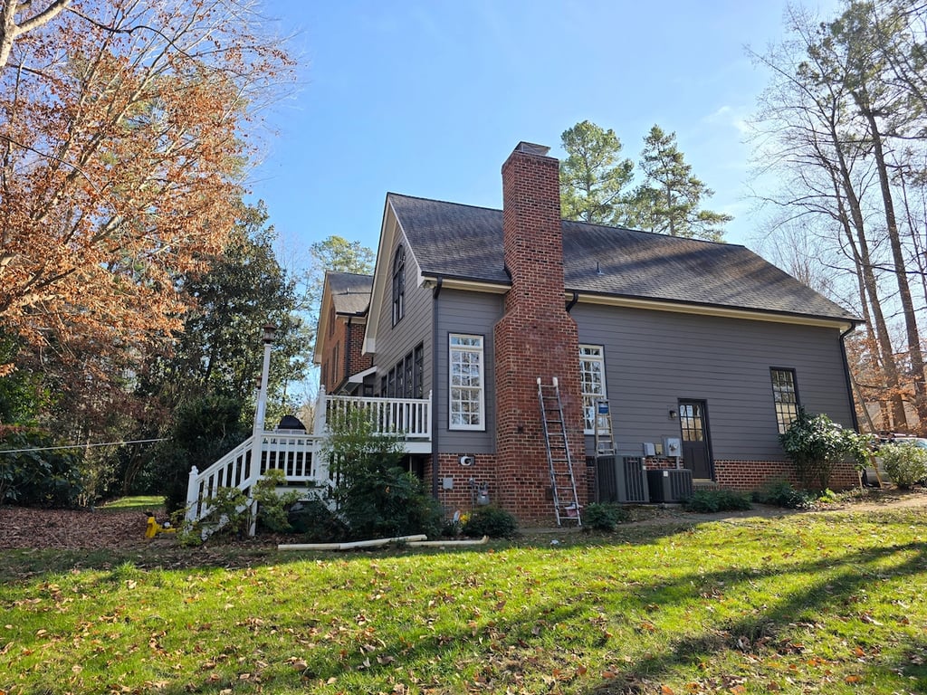 Dark-toned home exterior siding and trim on Durant Road in Raleigh, NC, professionally painted by A Touch of Color Painting & General Contracting using UV-resistant, thermal-stable coatings.