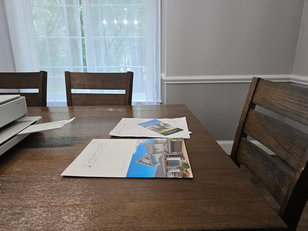 A Touch of Color Painting exterior presentation materials and paper contract on dinning room for a client to sign. 