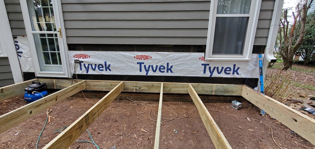 Professional construction of a deck substructure on Harrington Grove Drive in Raleigh, NC, featuring Madison Wood 2x10 floor joists to ensure high-load capacity and long-term structural durability.